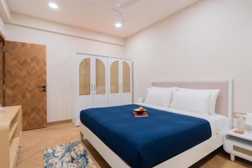 a bedroom with a large bed with a blue blanket at ELIVAAS 1 BHK with Jacuzzi & Lift - Kamerios Brisa in Goa