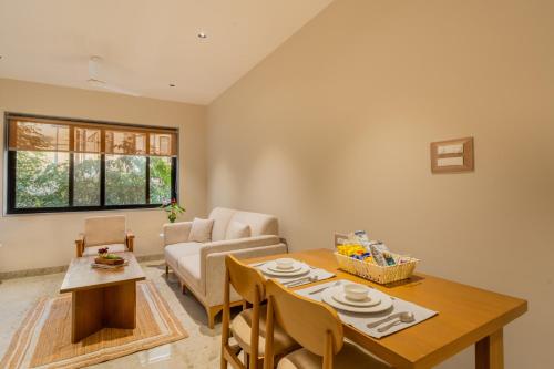 a living room with a table and a couch at ELIVAAS 1 BHK with Jacuzzi & Lift - Kamerios Brisa in Goa