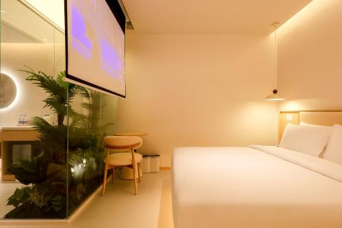 a hotel room with a bed and a flat screen tv at Mienbias Hotel Shenzhen in Shenzhen