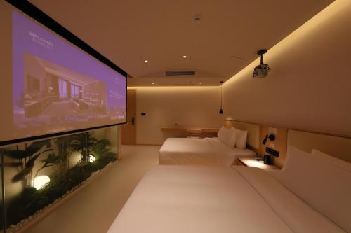 a hotel room with a bed and a flat screen tv at Mienbias Hotel Shenzhen in Shenzhen