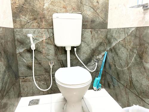 a white toilet in a bathroom with a shower at Mannat Inn Classic Premium - 3BHK in Mysore
