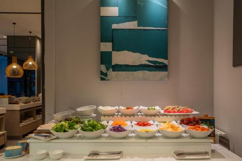a buffet with many bowls of food on a table at Arden Hotel and Residence by At Mind in Pattaya Central