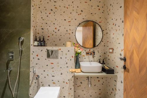 a bathroom with a sink and a mirror at ELIVAAS 1 BHK with Jacuzzi & Lift - Kamerios Brisa in Goa