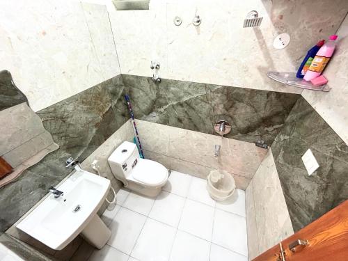 a bathroom with a toilet and a sink at Mannat Inn Classic Premium - 3BHK in Mysore