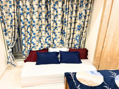 a bed with blue and white curtains in a room at Mannat Inn Classic Premium - 3BHK in Mysore