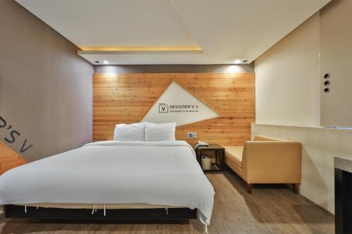 a bedroom with a large white bed and a couch at Moonbay Hotel in Busan