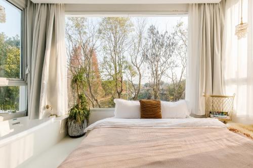 a bed in a room with a large window at Shanghai ruochu designer Guesthouse上海若初设计师民宿--近上海浦东国际机场及迪士尼 in Shanghai