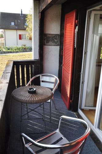 a table and chairs on a porch with a table and a table and chairs at Chalet-Biel-Bienne in Biel