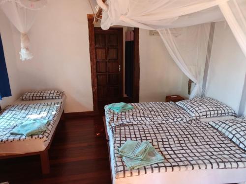 two twin beds in a room with atained at Suarez Hotel in Diego Suarez