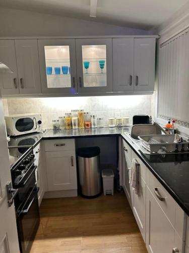 a kitchen with white cabinets and a counter top at One Bedroom Bungalow Loanhead, Midlothian, Nr Edinburgh in Loanhead