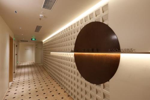 a hallway with a mirror on a wall at Mienbias Hotel Shenzhen in Shenzhen