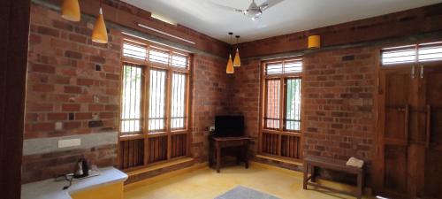 a room with brick walls and windows with a television at the motville in Pulpally