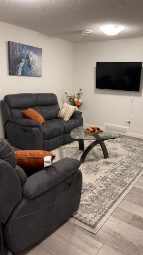 a living room with a couch and a table at Exquisite Basement Suite, 7mins away to Landmark Cinema and Malls in Calgary