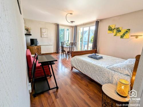une chambre avec un lit, une table et des chaises dans l'établissement La Levée - Balcon ensoleillé - Parking gratuit rue, à Orléans