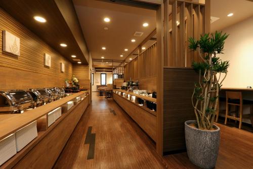 a restaurant with wooden walls and a long row of counters at Hotel Route-Inn Toyohashi Ekimae in Toyohashi