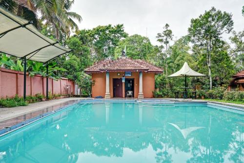 a swimming pool in front of a house at Palette - Pagoda Resorts in Cochin