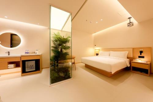 a bedroom with a bed and a mirror at Mienbias Hotel Shenzhen in Shenzhen