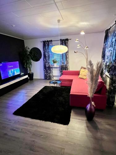 a living room with a red couch and a tv at Villa i Kiruna in Kiruna