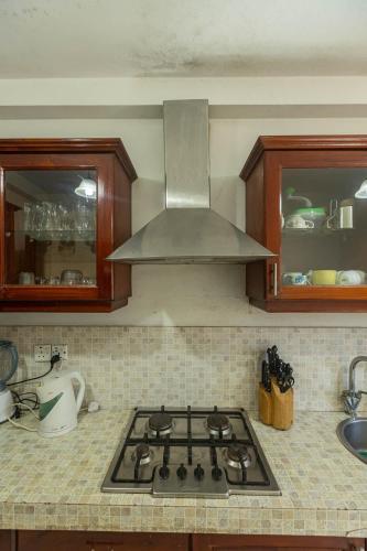 a kitchen with a stove top with a hood at Villa Wedamulla in Unawatuna