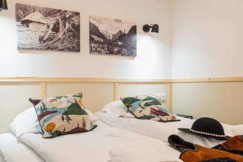 two beds with pillows and a hat on them at Panocek i Babka in Białka Tatrzanska
