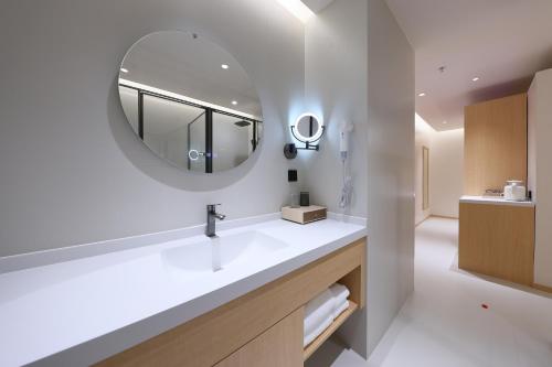 a bathroom with a sink and a mirror at Mienbias Hotel Shenzhen in Shenzhen