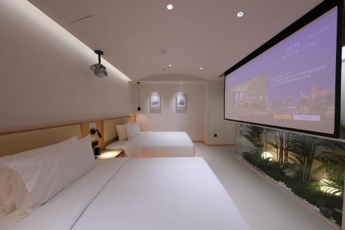 a hotel room with a bed and a large screen at Mienbias Hotel Shenzhen in Shenzhen