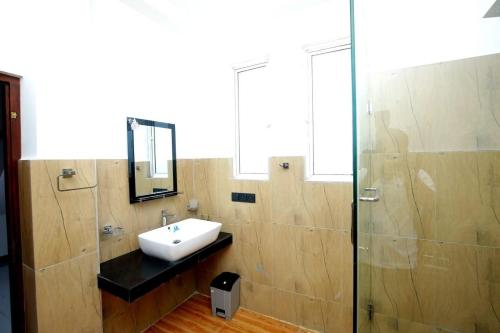 a bathroom with a sink and a glass shower at Villa Mathe in Dickwella