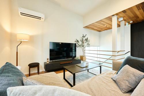 a living room with a couch and a tv at VILLA Naebo Sapporo Beer Park Hocance in Sapporo