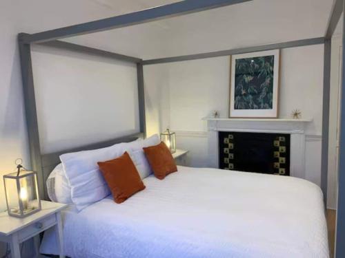 Peaceful apartment with courtyard in town centre في تيتبري: غرفة نوم بسرير ابيض وموقد