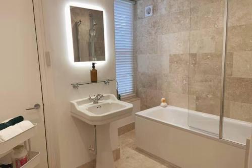 Peaceful apartment with courtyard in town centre في تيتبري: حمام مع مغسلة ودش وحوض استحمام