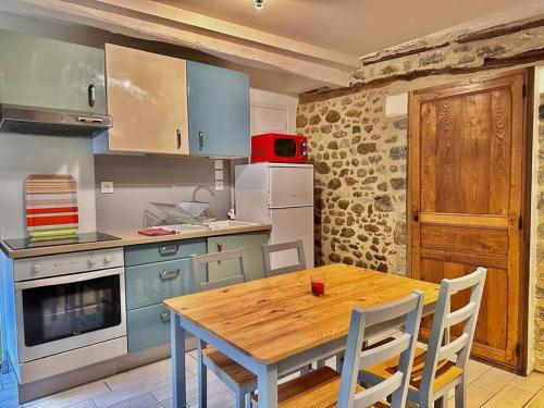 une cuisine avec une table en bois et une table et des chaises dans l'établissement Gîte - Tout confort et calme dans le centre ville, à Bécherel