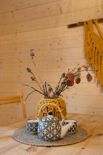 a blue and white vase with two cups on a table at Hotel Kouty - Lesní Apartmány in Ledeč nad Sázavou
