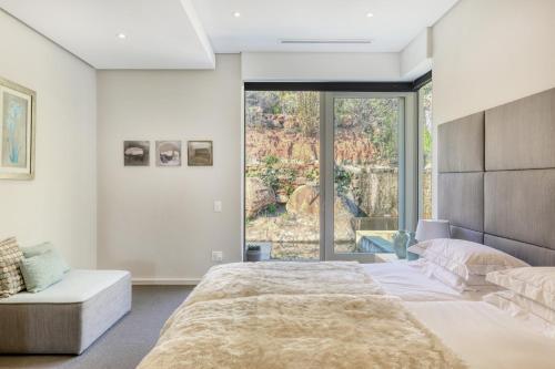 une chambre avec un grand lit et une grande fenêtre dans l'établissement Flightdeck, au Cap