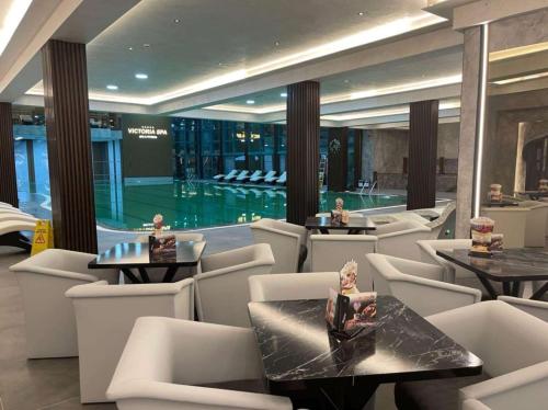 a restaurant with a swimming pool and tables and chairs at Ramada by Wyndham Sofia City Center in Sofia