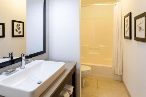 a bathroom with a sink and a toilet and a mirror at Country Inn & Suites by Radisson, Fargo, ND in Fargo