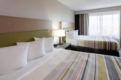 a hotel room with two beds and a window at Country Inn & Suites by Radisson, Fargo, ND in Fargo