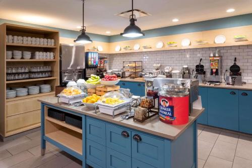 a kitchen with blue cabinets and food on a counter at Country Inn & Suites by Radisson, Fargo, ND in Fargo