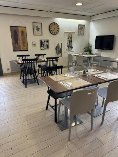une salle à manger avec des tables et des chaises et une horloge dans l'établissement Campanile Saint-Avold, à Saint-Avold
