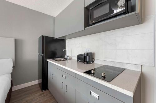 a kitchen with a sink and a microwave at MainStay Suites MSP Airport - Mall of America in Bloomington