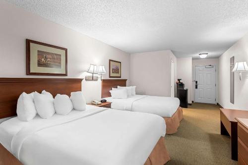 a hotel room with two beds and a desk at Quality Inn in Blackwell