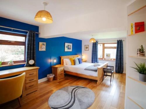 a bedroom with a bed and a blue wall at Carden Hill House - 4 Bedrooms - Sleeps 9 - Free Parking - Games Room - Ideal for Contractors, Families and Large Groups in Brighton & Hove