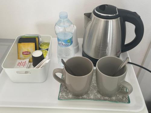 two cups on a tray next to a water bottle at VILLA SIMONA Malpensa in Gallarate