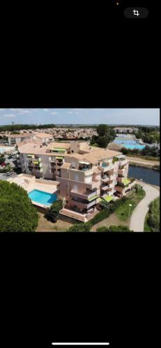 une vue aérienne d'un immeuble avec piscine dans l'établissement Le grau du roi, au Grau-du-Roi