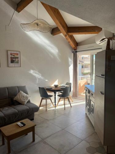 un salon avec un canapé et une table dans l'établissement Le grau du roi, au Grau-du-Roi