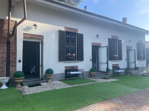 a white house with a green lawn in front of it at VILLA SIMONA Malpensa in Gallarate