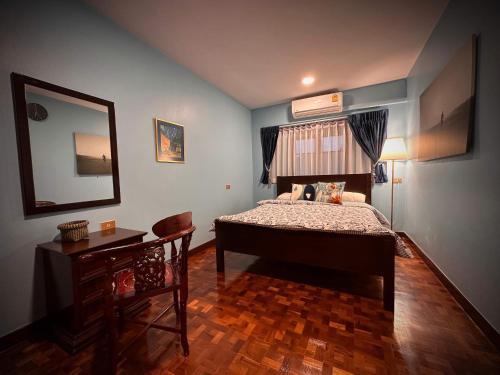 a bedroom with a bed and a mirror and a table at Newly-renovated Modern Private Thai Villa with Swimming Pool in Ban Khlong Samrong
