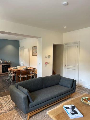 a living room with a couch and a table at Gite des usines de moulins in Anhée