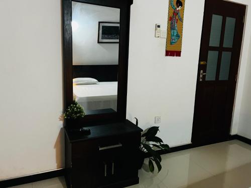 a mirror sitting on top of a dresser in a room at Cactus Piliyandala in Piliyandala