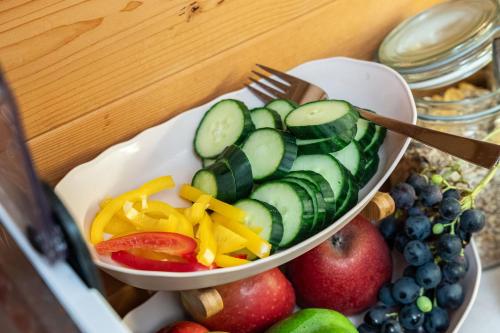 a bowl of cucumbers and other fruits and vegetables at Frühstückspension Müllergut in Sankt Martin bei Lofer