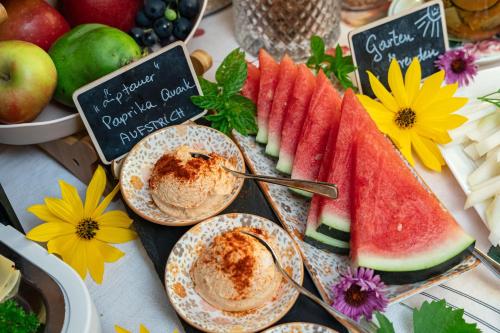 a table topped with plates of food with fruit at Frühstückspension Müllergut in Sankt Martin bei Lofer